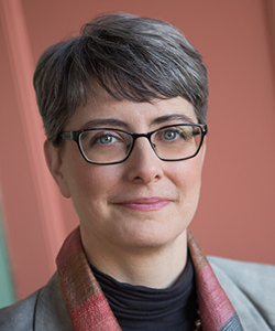 Jennifer Zelmer, seen from the shoulders up, wearing a grey blazer, glasses, and short grey hair